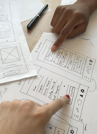 hands pointing at paper prototypes